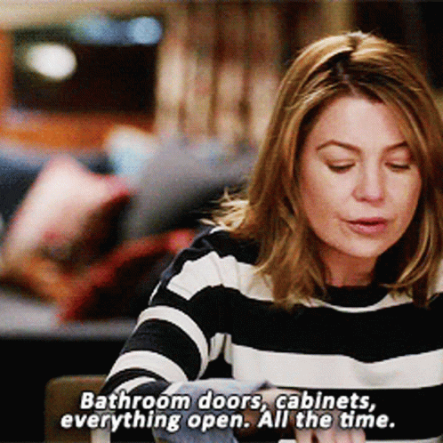 Woman In Striped Sweater Says Bathroom Doors Cabinets Always Open GIF