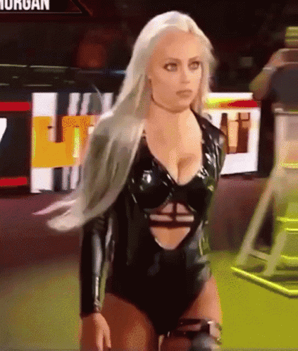 A Woman In A Black Bodysuit Is Standing In Front Of A Sign That Says ' Morgan ' On It GIF