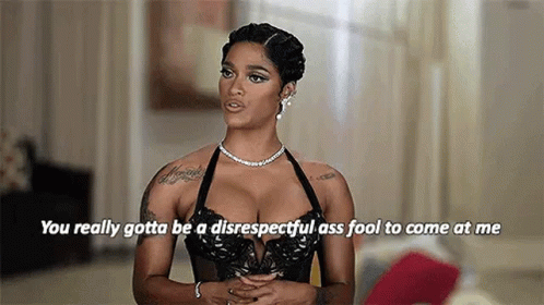A Woman In A Black Bra And A Necklace Is Talking To Someone . GIF