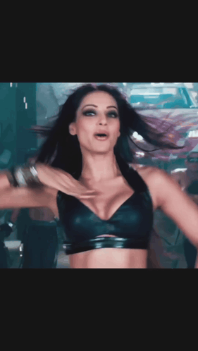 A Woman In A Black Bra Is Dancing In Front Of A White And Red Car GIF