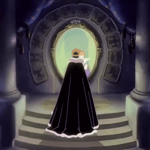 A Woman In A Black Cape Stands In Front Of A Mirror With A Crown On Her Head GIF
