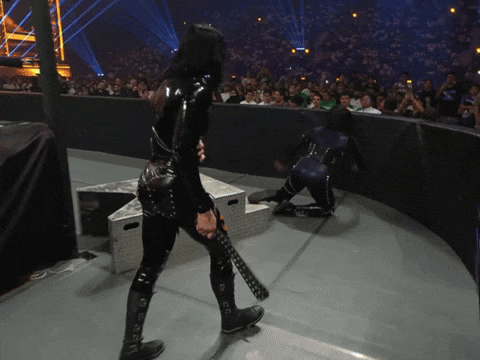 A Woman In A Black Catsuit Is Holding A Sword GIF
