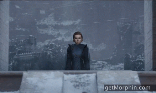 a woman in a black coat stands in front of a wall with the website getmorphin.com below her