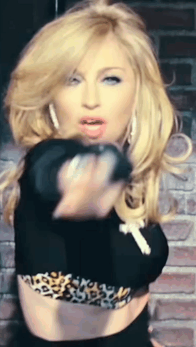 A Woman In A Black Crop Top With A Leopard Print Is Pointing At The Camera GIF