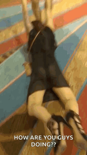A Woman In A Black Dress And High Heels Is Laying On The Floor And Asking How Are You Guys Doing ? GIF