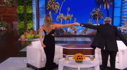 A Woman In A Black Dress Is Dancing With A Man In A Black Suit On The Ellentube Show GIF