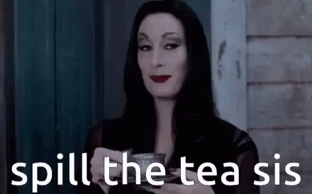 A Woman In A Black Dress Is Holding A Cup Of Tea . GIF