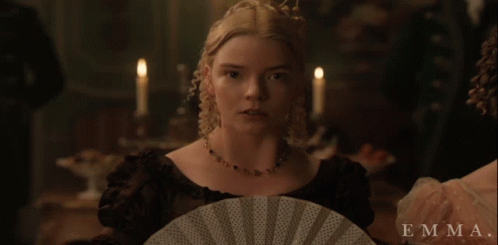 A Woman In A Black Dress Is Holding A Fan And The Name Emma Is On The Bottom GIF