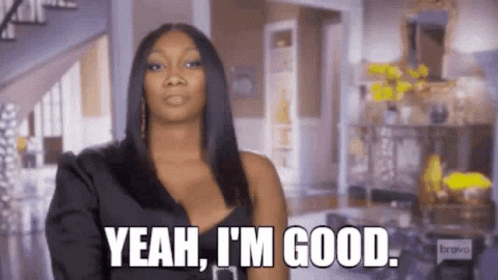 A Woman In A Black Dress Is Standing In A Living Room And Saying `` Yeah , I 'M Good '' . GIF