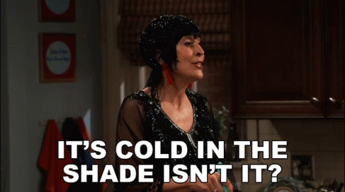 A Woman In A Black Dress Says " It 'S Cold In The Shade Isn 'T It " GIF