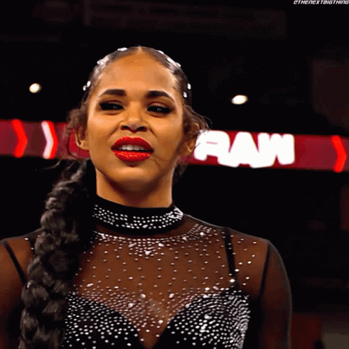 A Woman In A Black Dress Stands In Front Of A Raw Sign GIF