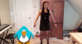 A Woman In A Black Dress Stands Next To A Penguin GIF
