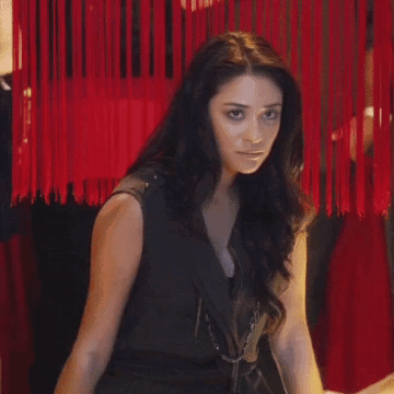 A Woman In A Black Dress Stands Next To Another Woman GIF