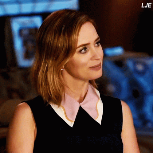 A Woman In A Black Dress With A Pink And White Collar Has The Word Lje On The Bottom Right GIF