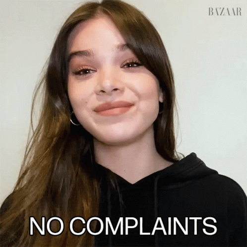A Woman In A Black Hoodie Says No Complaints In Front Of Her Face GIF