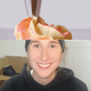 a woman in a black hoodie smiles in front of a picture of an apple