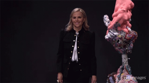 A Woman In A Black Jacket Is Standing In Front Of A Sculpture With The Words Gettyimages On The Bottom Right GIF
