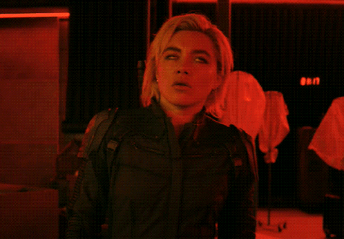 a woman in a black jacket stands in front of a red sign that says ' gen '