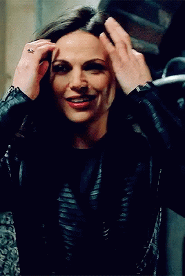 A Woman In A Black Leather Jacket Holds Her Hair Up GIF