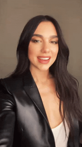 A Woman In A Black Leather Jacket Is Smiling GIF