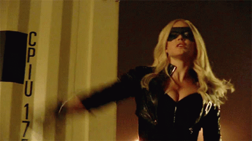 A Woman In A Black Mask Is Standing In Front Of A Sign That Says Cpiu 17 GIF