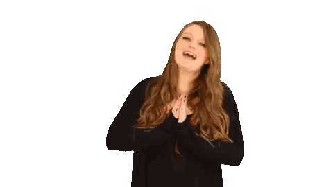 a woman in a black shirt is laughing and clapping
