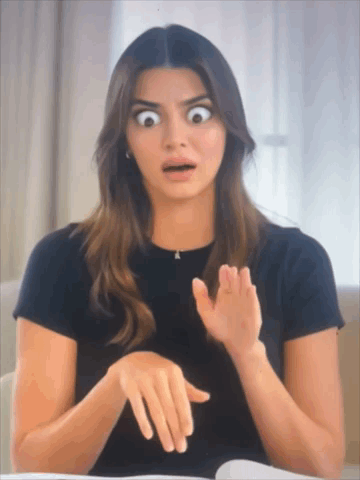 A Woman In A Black Shirt Is Making A Funny Face GIF