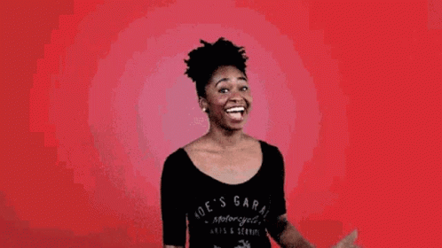 A Woman In A Black Shirt Is Making A Gesture With Her Fist In The Air . GIF