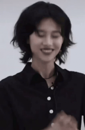 A Woman In A Black Shirt Is Smiling With Her Eyes Closed . GIF