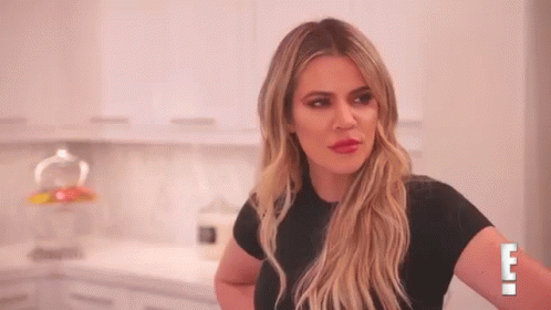 A Woman In A Black Shirt Is Standing In A Kitchen With Her Arms Crossed . GIF