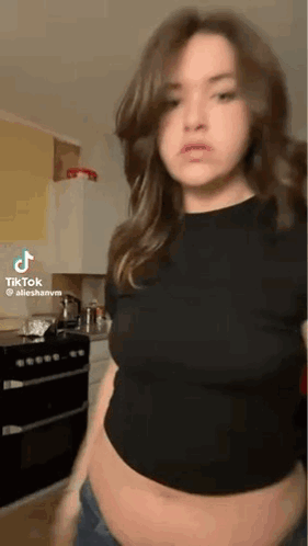 Woman In Kitchen With Exposed Belly GIF