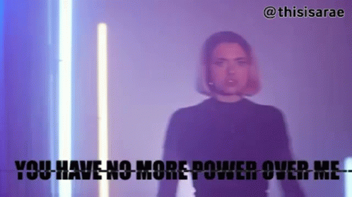 A Woman In A Black Shirt Is Standing In Front Of A Neon Light And Says You Have No More Power Over Me . GIF