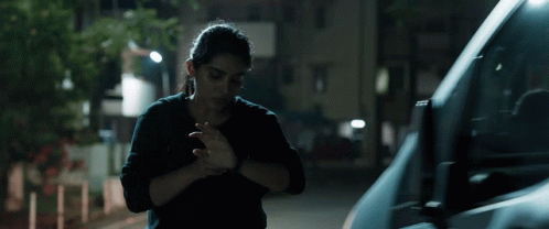 A Woman In A Black Shirt Is Standing Next To A Van GIF