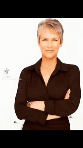 A Woman In A Black Shirt Is Standing With Her Arms Crossed On A White Background . GIF