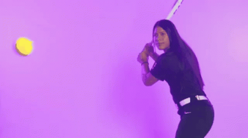 a woman in a black shirt is throwing confetti in the air against a purple background
