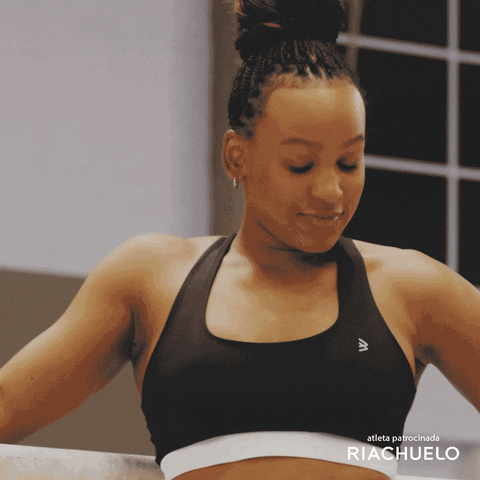 A Woman In A Black Sports Bra With The Word Riachuelo On It GIF