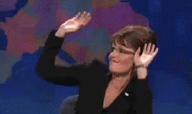 A Woman In A Black Suit Is Dancing On A Stage . GIF