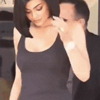 a woman in a black tank top is standing next to a man in a black suit .