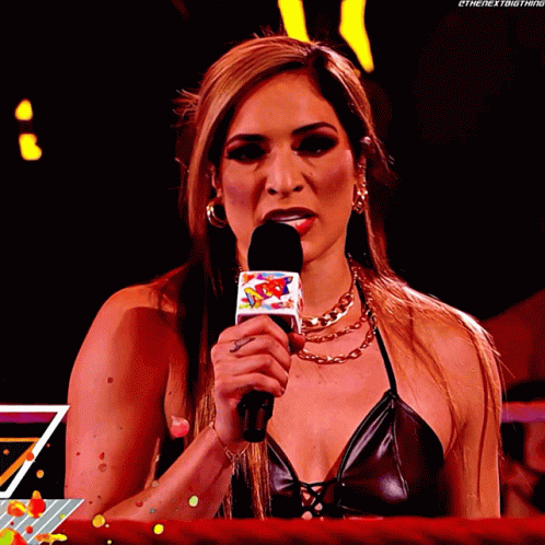A Woman In A Black Top Is Holding A Microphone That Says ' Ethenextbigthing ' On It GIF