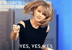 A Woman In A Black Top Is Pointing At The Camera And Saying Yes . GIF