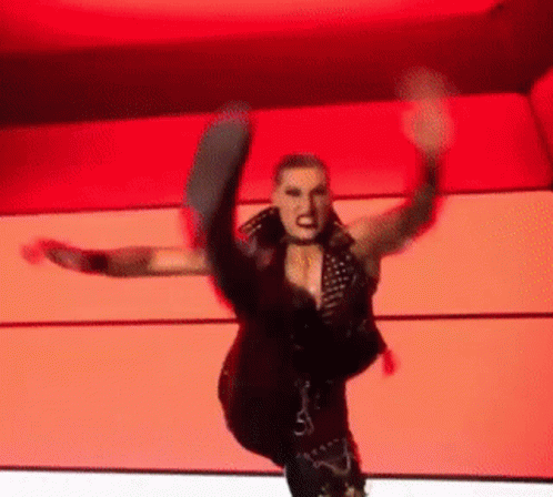 A Woman In A Black Vest Is Kicking Her Leg In The Air GIF