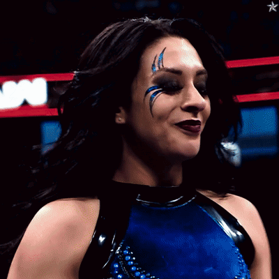 A Woman In A Blue And Black Outfit With A Star In The Background GIF