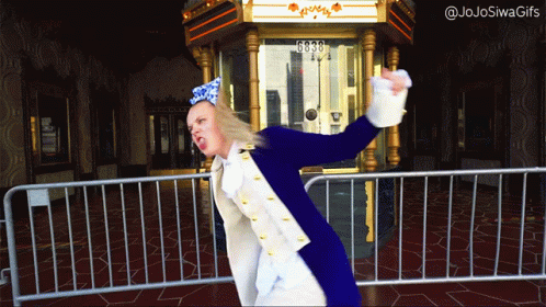 A Woman In A Blue And White Costume Is Standing In Front Of A Fence With The Number 6030 On It GIF