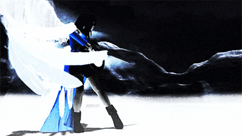 A Woman In A Blue And White Dress Is Dancing In The Dark GIF