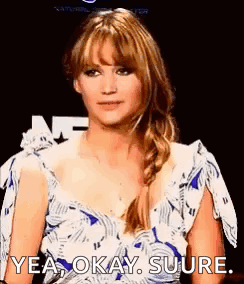 A Woman In A Blue And White Dress Is Making A Funny Face And Saying `` Yea Okay Sure . '' GIF