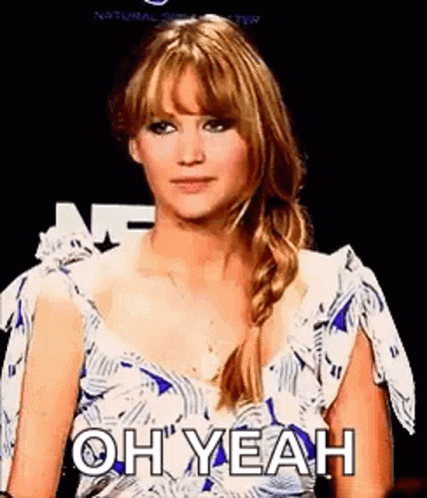 A Woman In A Blue And White Dress Is Making A Funny Face . GIF