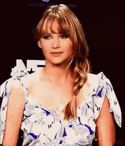 A Woman In A Blue And White Dress With A Braid Is Making A Funny Face . GIF