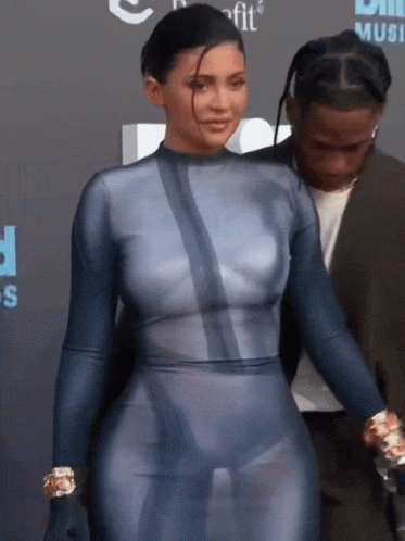 A Woman In A Blue Bodysuit Is Standing Next To A Man GIF