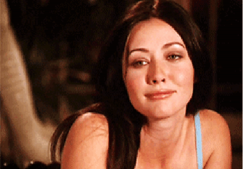A Woman In A Blue Bra Looks At The Camera With A Smile On Her Face GIF