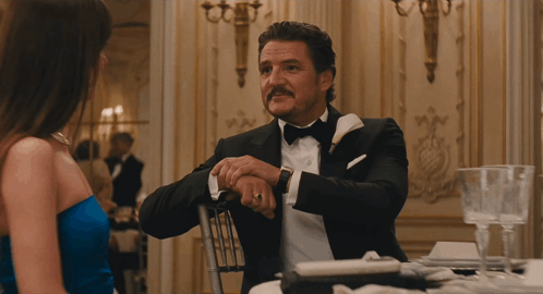 a woman in a blue dress and a man in a suit are looking at each other